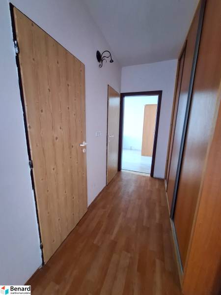 A hallway with built-in wardrobes and a floor with a wooden decor in a 3-room apartment.