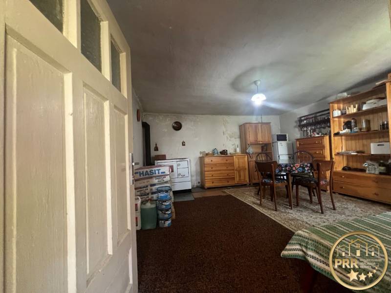 An interior with wooden furniture, a carpet, a table, and a cabin provides a rustic atmosphere.