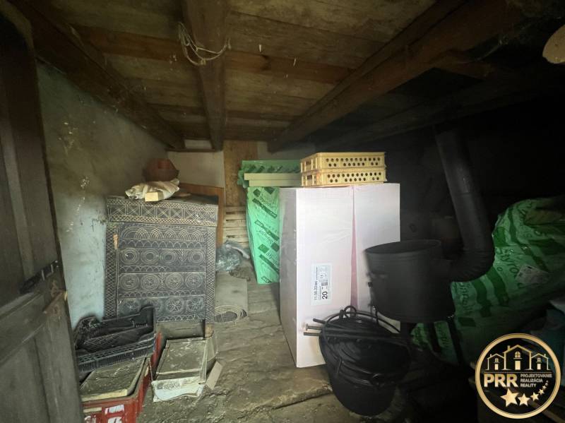 Storage space in a cottage in Šípkov with a decorative stove and various boxes.