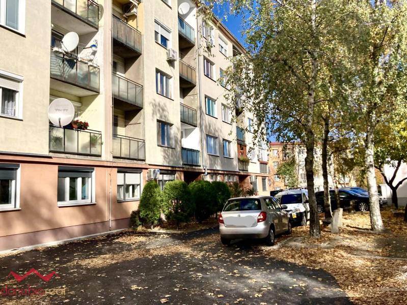 Apartment building on Mederčská in Komárno with parked cars and trees.