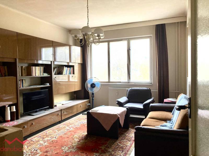 Living room in a 3-room apartment with furniture, a carpet, and a large window.