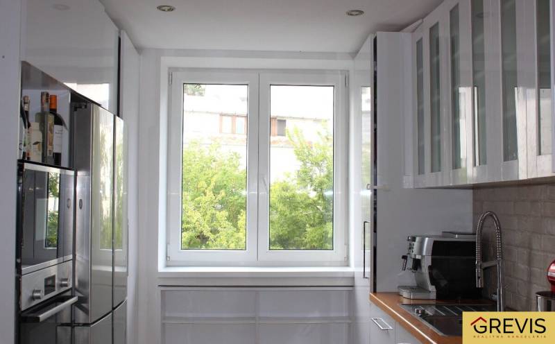 A kitchen in a 3-room apartment with a bright window and modern appliances.