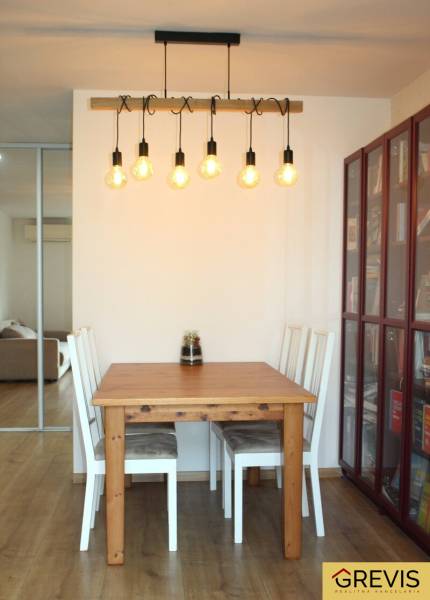 Dining area with a table and chairs, floor with wooden decor, 3-room apartment.