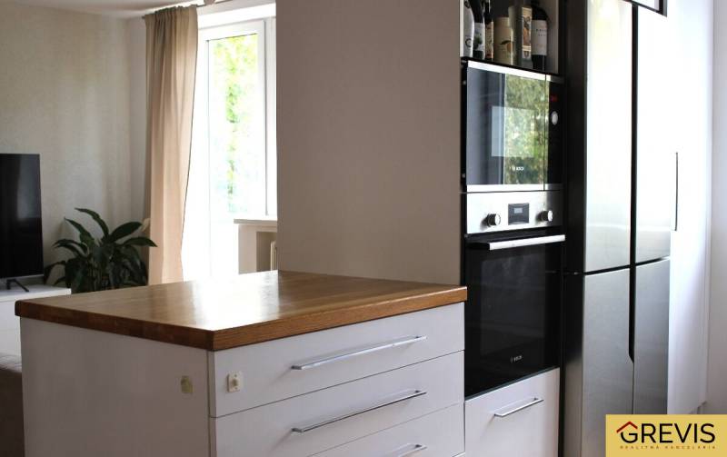 Kitchen in a 3-room apartment, dark cabinet with built-in oven, next to the refrigerator.