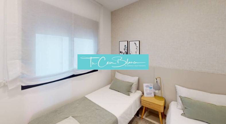 A room in a vacation apartment with two single beds and subtle wall decorations.