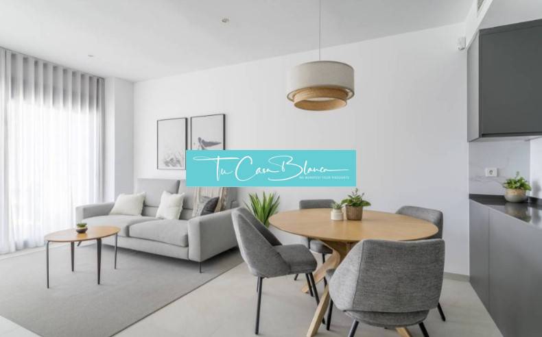 Bright living room of the holiday apartment with a gray armchair and a wooden table.