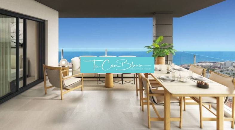 View from the spacious terrace of a holiday apartment in Torrevieja with furniture and the ocean.