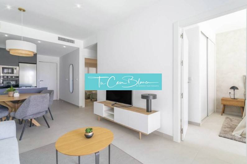 Recreational apartment with an open living room, dining table, and wood-decorated flooring.