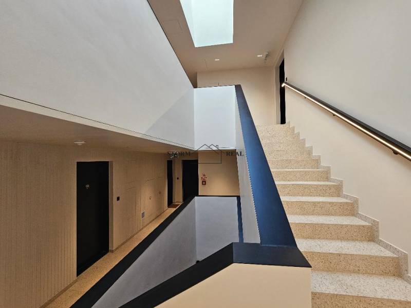 A staircase with terrazzo steps and a bright ceiling in a 3-room apartment.