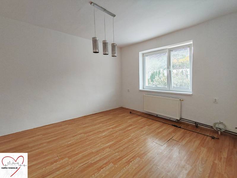 A room in a family house with a wooden decor floor and a large window.