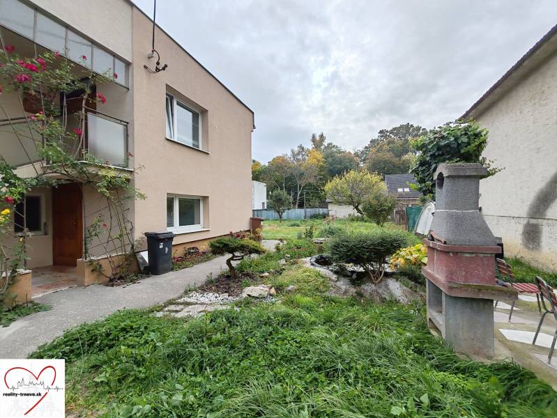 The family house on Topoľová Street in Sereď has a green garden with an outdoor fireplace.