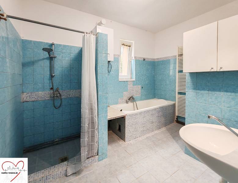 A bathroom in a family house with blue tiles, a shower, and a bathtub.