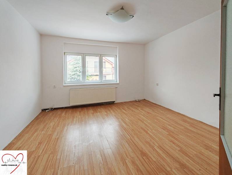 A room in a family house with a wooden decor floor and a large window.