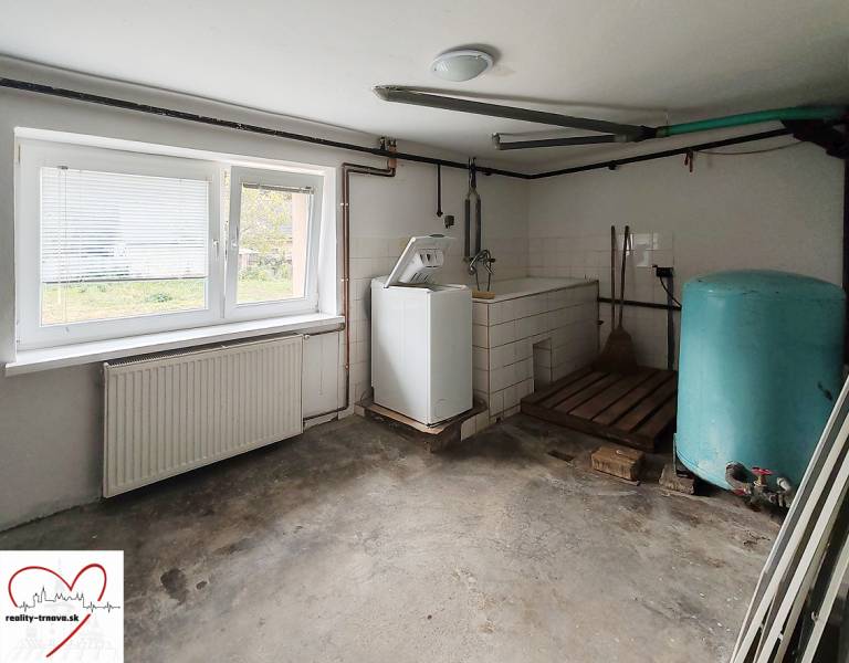 Technical room with a washing machine and a storage tank in a family house. Floor with wood decor.