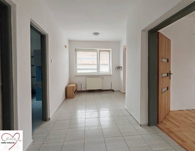 Interior of a family house with tiling, wooden decor flooring, and a radiator.