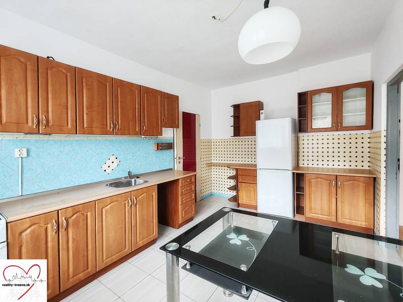 A family house kitchen with wooden cabinets, white tiles, and blue wall tiles.