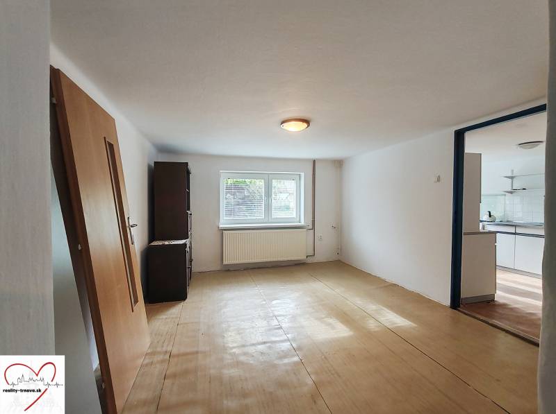 A room with a wooden floor decor in a family house, exit to the kitchen.