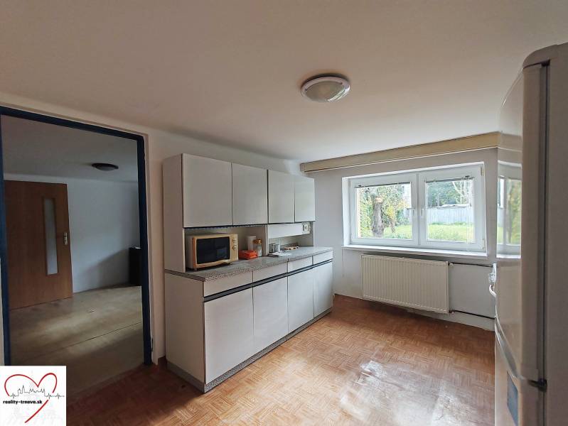 A kitchen in a family house with white cabinets and a floor with a wood decor.