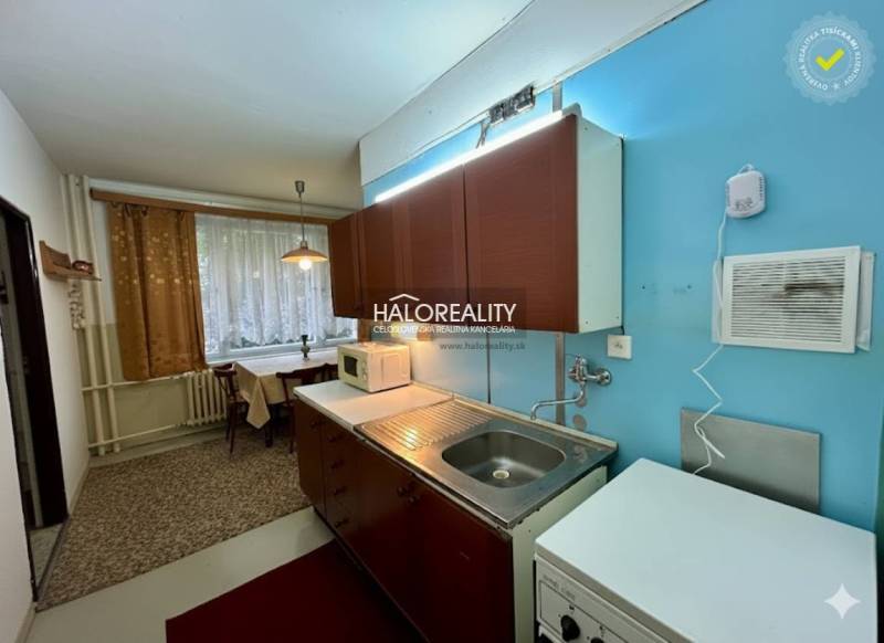 A kitchen with a light blue wall and a dining area in a 4-room apartment.