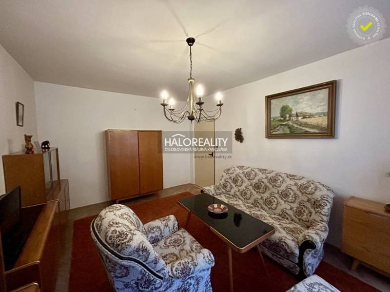 Living room in a 4-room apartment with classic furniture and an elegant chandelier.