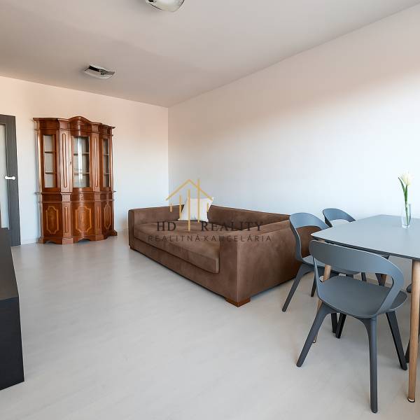 Living room with a sofa and a display cabinet, wooden decor flooring in a 3-room apartment.