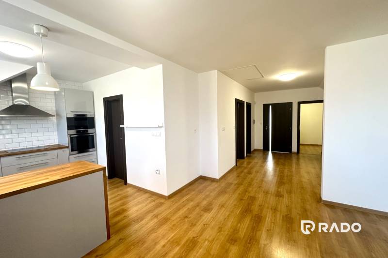 A kitchen in a family house with a wood-patterned floor and white walls.