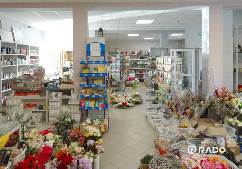 The interior of a store with a variety of flowers, decorations, and various household items.