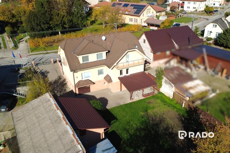 A family house in Bolešov surrounded by greenery, with a courtyard and several outbuildings.