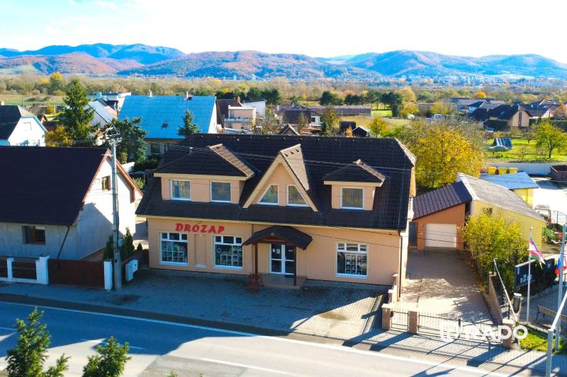A family house in Bolešov with mountains in the background and a parking lot in front of the building.