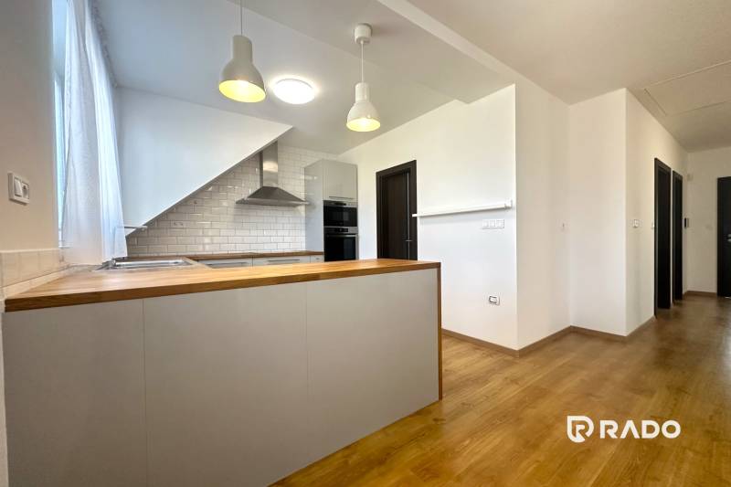 A kitchen in a family house with a wooden decor floor and white tiles.