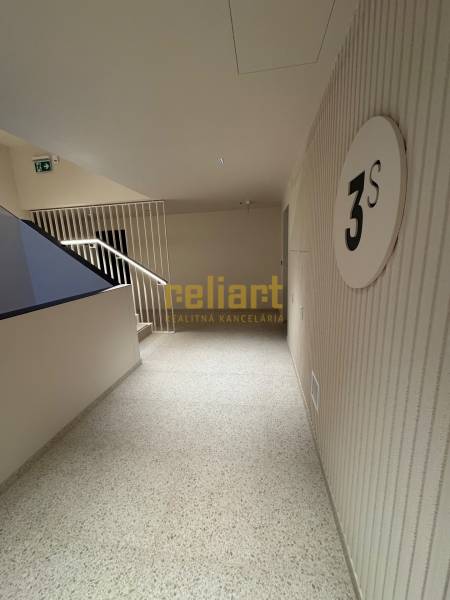 Hallway with floor designation, stairs, and safety signage.