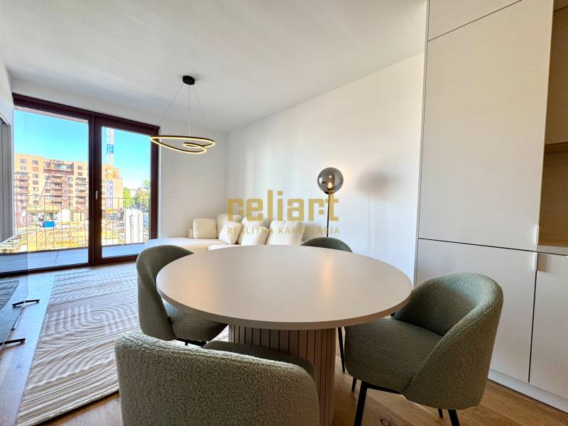 A two-room apartment with a wooden decor floor and a round dining table.