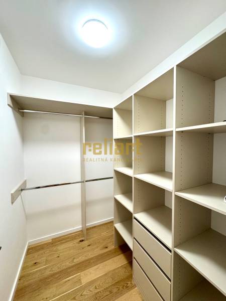 A wardrobe in a 2-room apartment with shelves and a floor with a wooden decor.