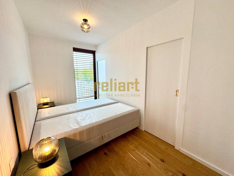 Bedroom in a 2-room apartment with a bed, lamps, and a floor with a wooden decor.