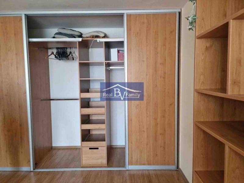 A built-in wardrobe with sliding doors and a wooden decor in a 2-room apartment.