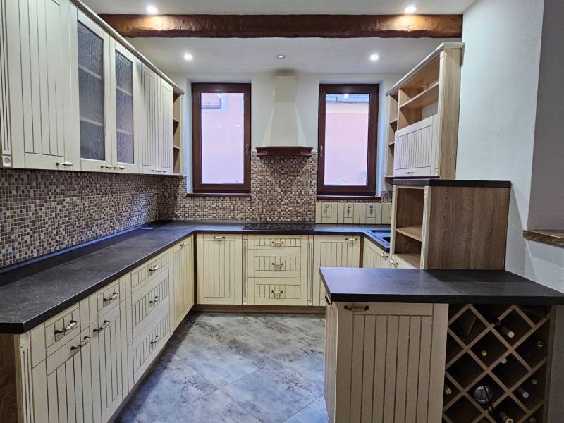 A kitchen with a tiled floor and wooden decor in a family house.