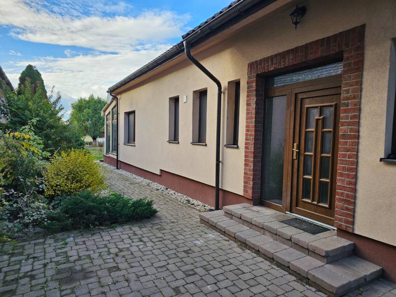 Family house on Štúrova Street in Vráble with brick cladding and garden landscaping.