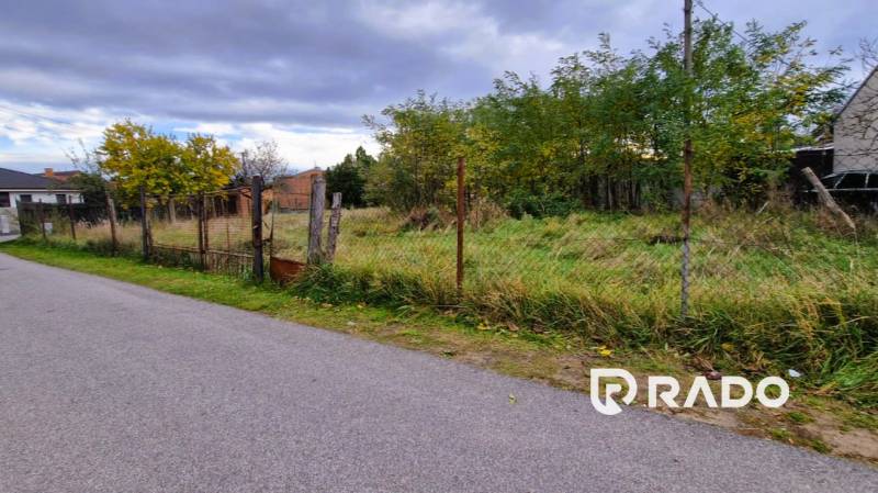Residential plots in Gajary with visible fencing and surrounding trees offer tranquility.
