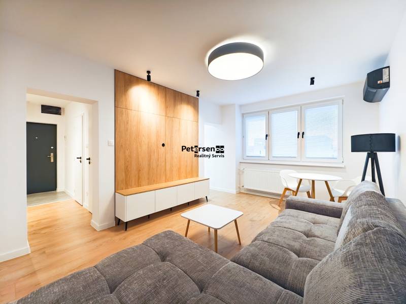 Living room with a sofa, dining table, wooden floor decor in a two-room apartment.