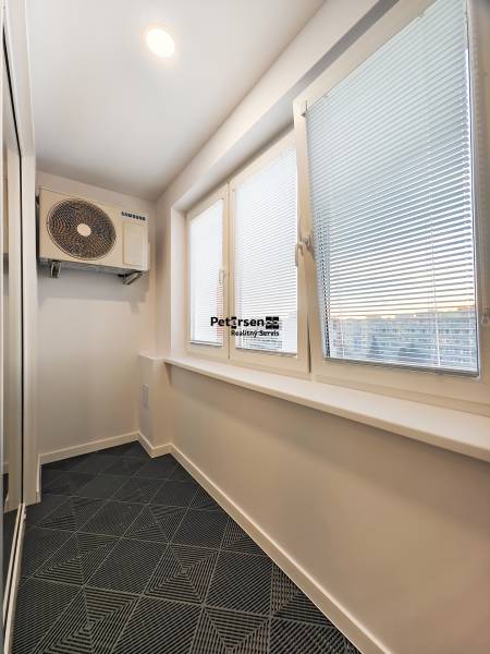 A narrow room with air conditioning and blinds in a 2-room apartment.
