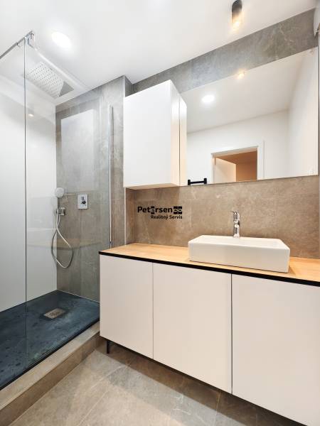 Bathroom in a 2-room apartment with a modern shower and a large mirror.