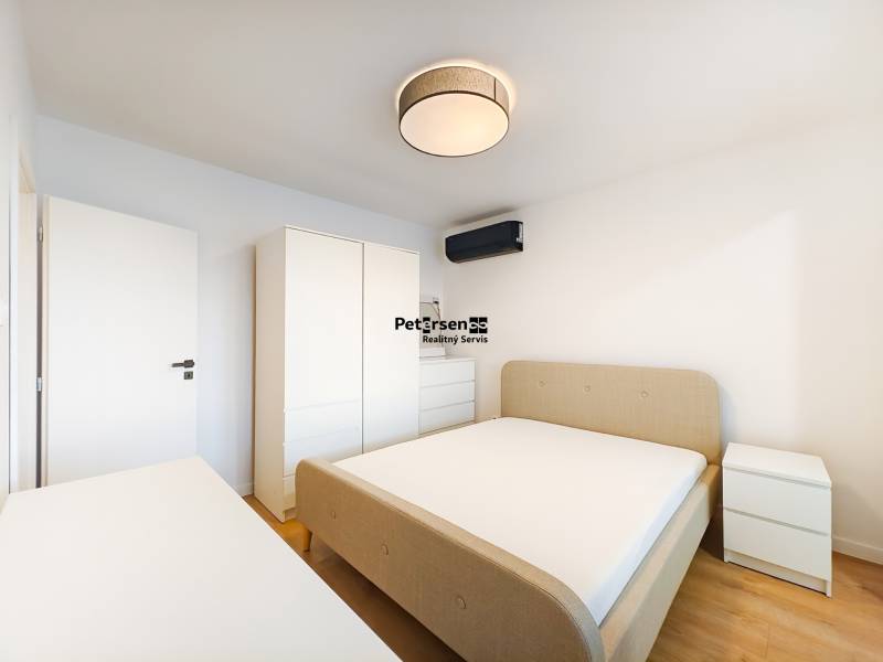 Bedroom in a 2-room apartment with a bed, wardrobe, chest of drawers, and floor with a wooden decor.