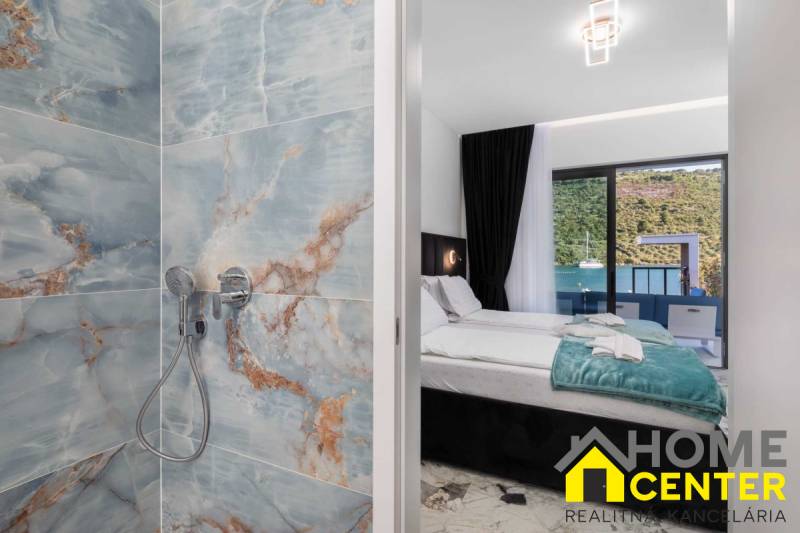 Bathroom with marble tiles and a bedroom in a villa with a sea view.