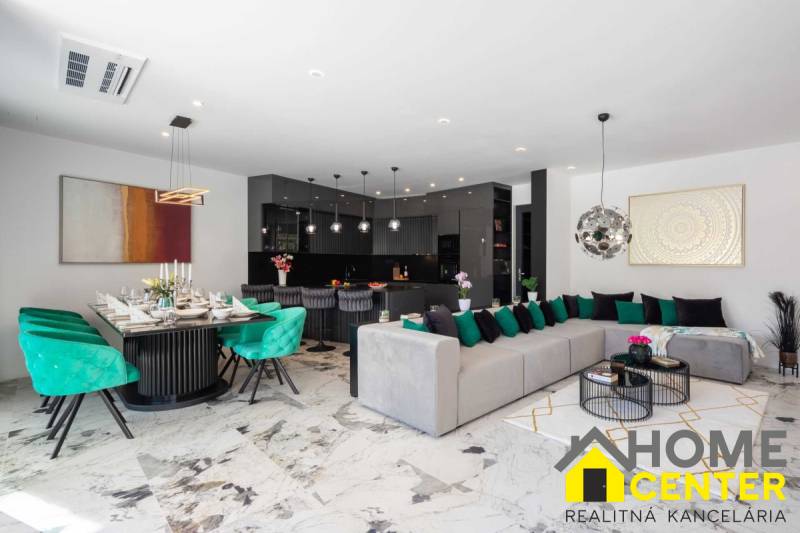 Spacious living room of the villa with a dining area, sofa, and modern kitchen.