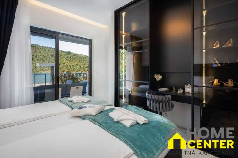 Bedroom in a villa with a terrace and a view of nature and the lake.