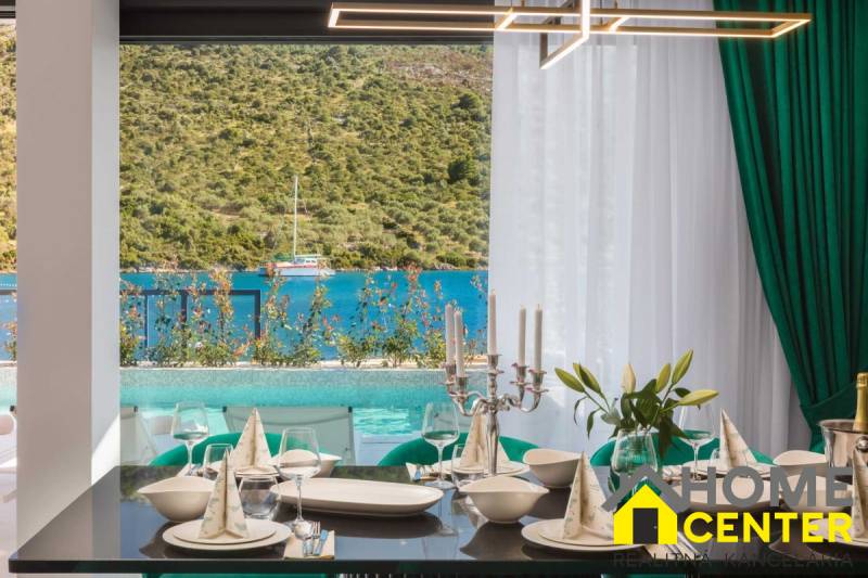 Elegant dining with a view of the pool and the sea in the villa.