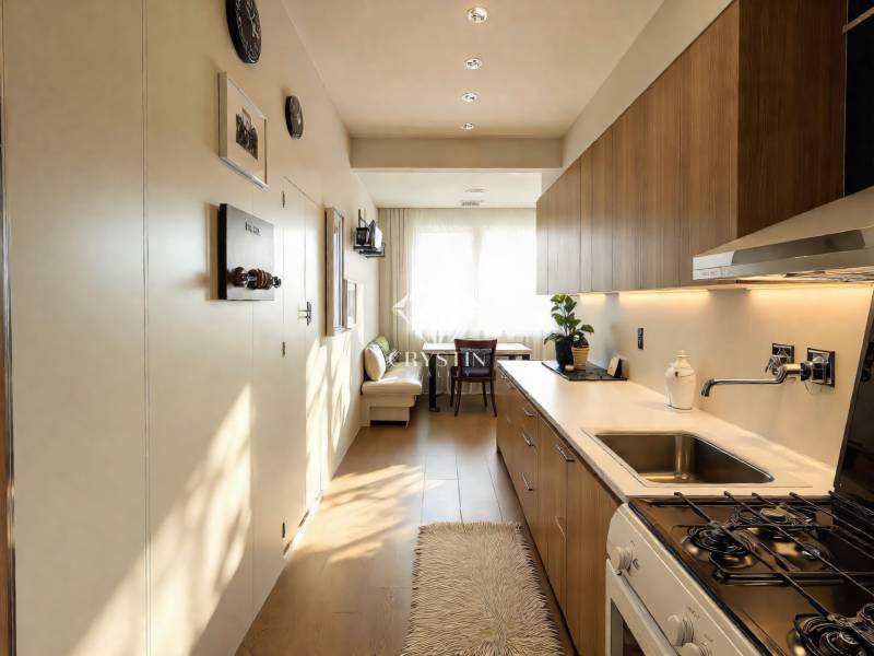 Cozy kitchen in a 3-room apartment with a wood-patterned floor and modern furnishings.
