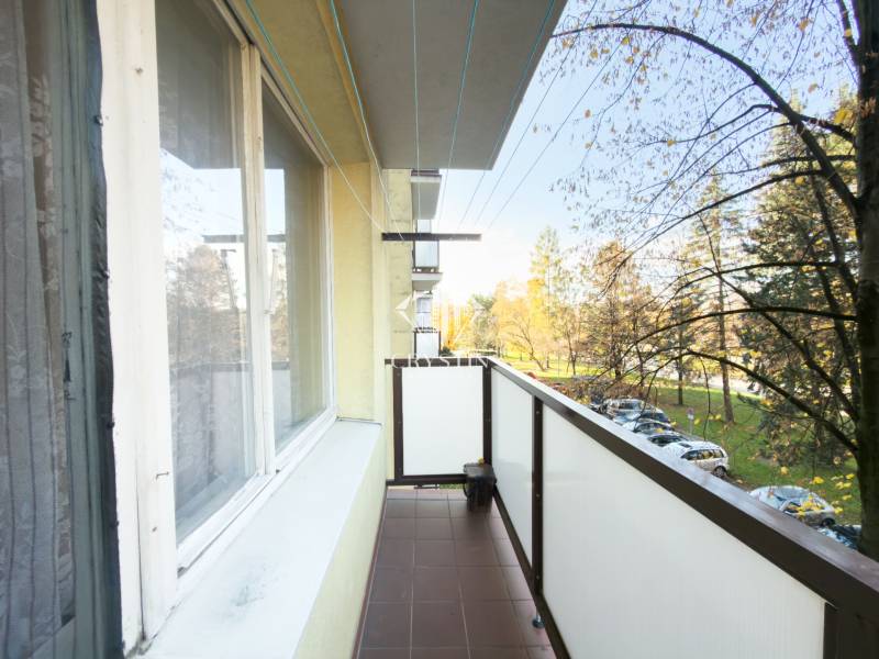 A balcony with a view of greenery and parked cars from a 3-room apartment on Pittsburgská Street in Žilina.