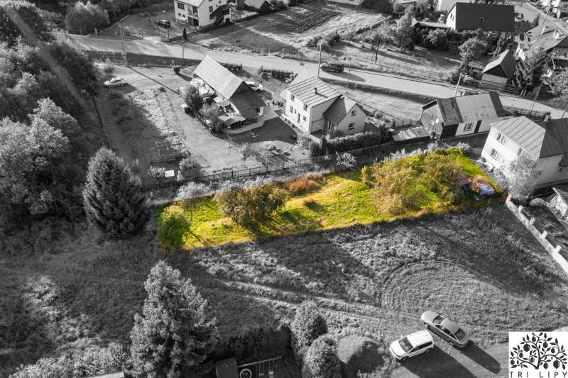 An aerial photograph captures residential plots in the town of Turzovka surrounded by greenery and houses.