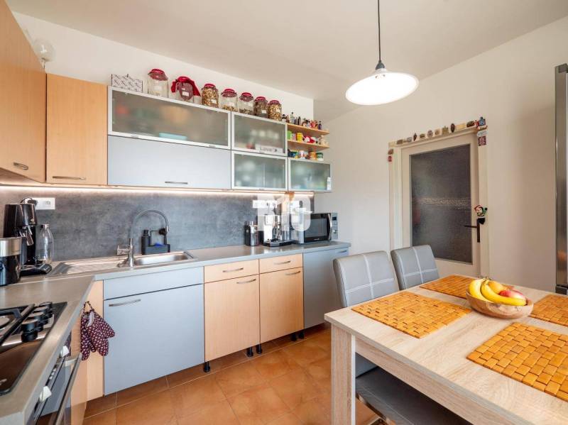 A kitchen in a 4-room apartment with a computer and a kitchen unit in wooden decor.